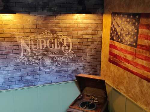 A vintage record player in a cozy room with a brick wall and an American flag hanging nearby.