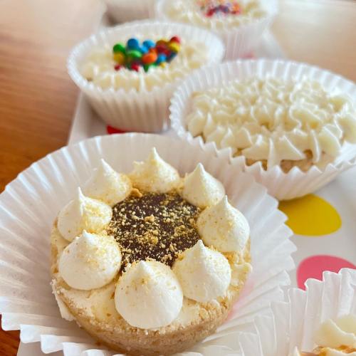 A close-up of a dessert with cream frosting and a chocolate center, surrounded by colorful treats on a tray.