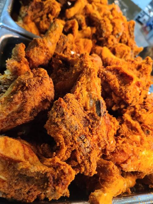 A close-up of crispy, golden-brown fried chicken wings piled together.