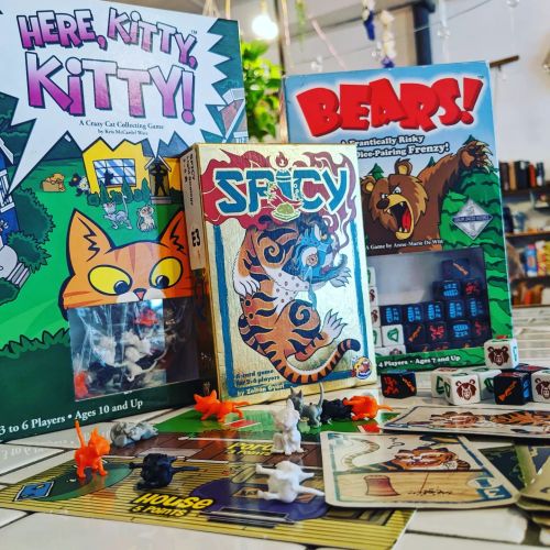 A tabletop game display featuring "Here, Kitty, Kitty!", "Bears!", and "Spicy" with colorful game pieces and dice.