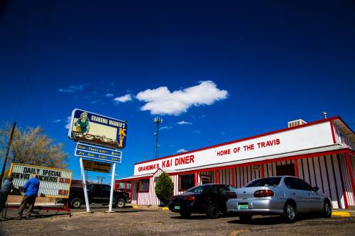 A diner with a red and white exterior, featuring a sign that reads "Grandma's K&I Diner" under a blue sky.