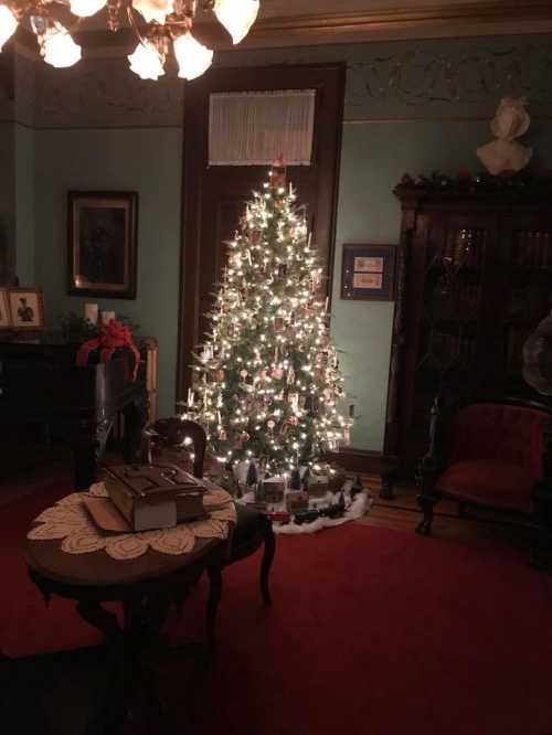 A warmly lit room featuring a decorated Christmas tree, vintage furniture, and festive decorations.