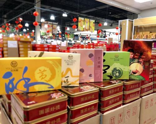Colorful boxes of tea and snacks displayed in a store, with festive decorations in the background.