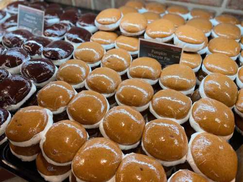 A display of pumpkin and chocolate whoopie pies arranged neatly on a tray.
