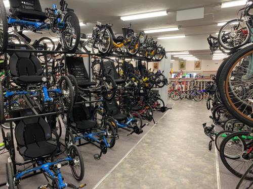 A spacious bike shop filled with various bicycles and tricycles displayed on racks and along the aisles.