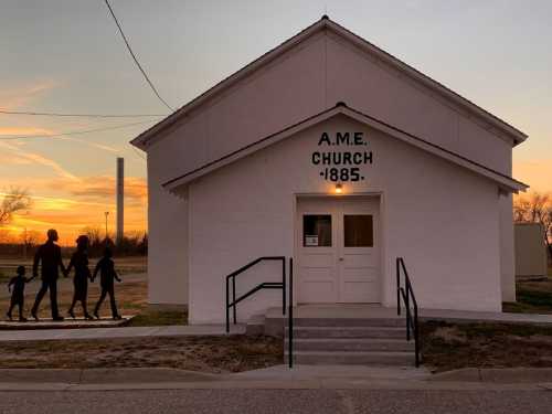 Silhouettes of a family walking in front of a white church building at sunset, with "A.M.E. Church 1885" displayed.