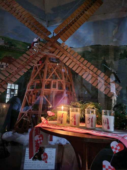 A windmill model with candles and decorations, set in a festive display.