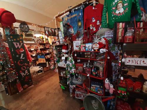 A cozy holiday shop filled with festive decorations, ornaments, and Christmas-themed items.