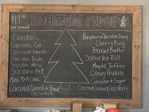 Chalkboard menu listing various homemade fudge flavors, including chocolate, peanut butter, and raspberry chocolate dream.