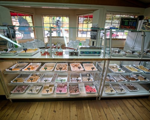 A display case filled with various ice cream flavors and toppings in a bright, inviting shop.