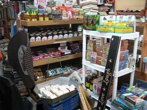 A cozy bookstore corner filled with shelves of books, snacks, and various packaged goods, creating a warm atmosphere.