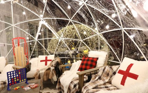Cozy igloo-style seating area with blankets, pillows, and string lights, creating a warm atmosphere.