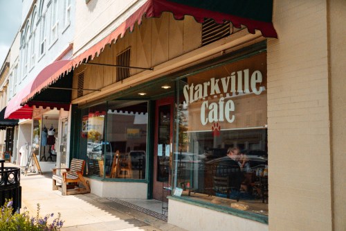 Exterior of Starkville Cafe with a red awning, showcasing large windows and a welcoming entrance.