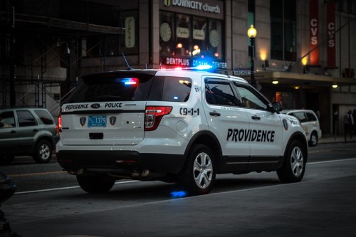 A Providence police SUV with flashing lights parked on a city street at night.