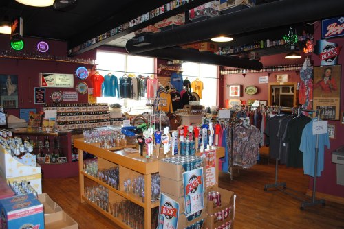 A colorful retail store interior filled with merchandise, including clothing, drinks, and various souvenirs.