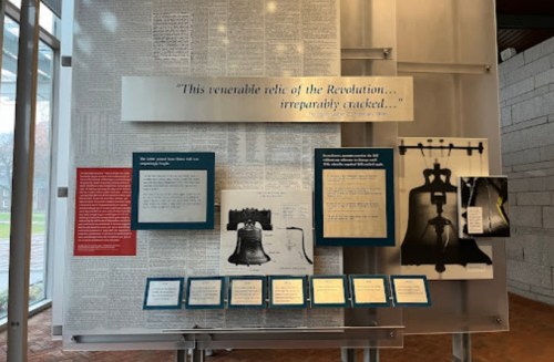Exhibit display featuring historical documents and images related to the Liberty Bell and its significance.