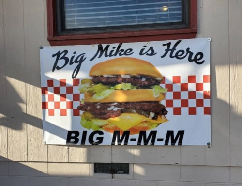 Banner advertising "Big Mike is Here" featuring a large burger with two patties, lettuce, and cheese.