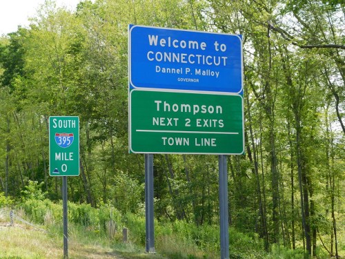 Welcome sign for Connecticut with "Thompson Next 2 Exits" and a mile marker for I-395 South. Green and blue signage.
