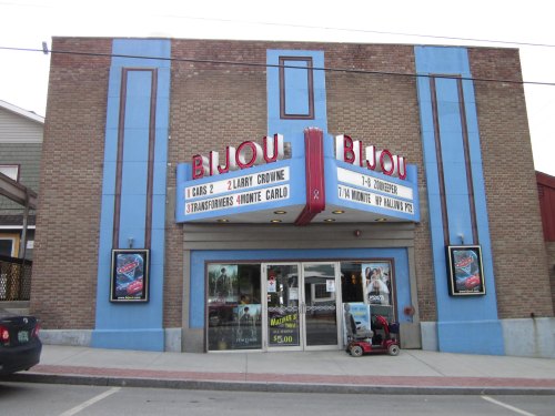 The exterior of the Bijou Theater, featuring a marquee with movie titles and a classic brick facade.