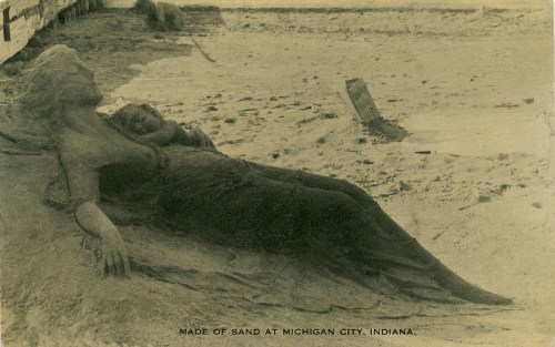 A sand sculpture of a woman reclining with a child, set on a beach in Michigan City, Indiana.