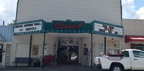 Exterior of the Carol Theatre Antique Mall, featuring a marquee and vintage decor, with a white truck parked outside.