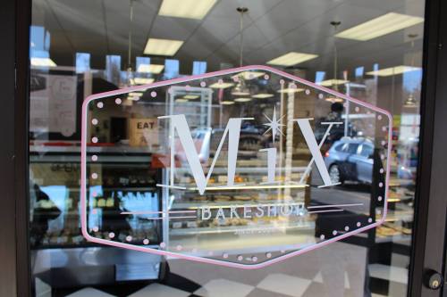 A storefront window featuring the "MiX Bakeshop" logo with a display of baked goods visible inside.