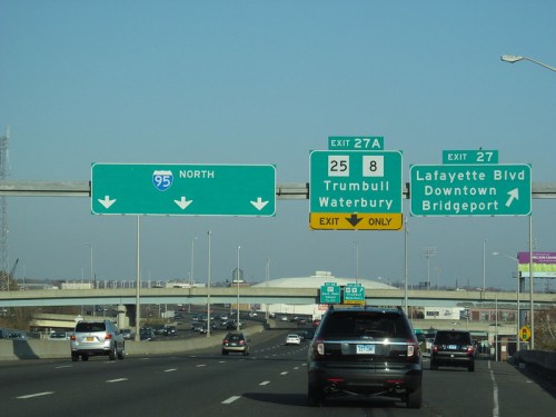 Highway sign indicating exits for I-95 North, Trumbull, Waterbury, and Bridgeport with traffic below.