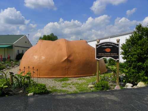 A large, rounded, orange structure resembling a giant peach, with a sign indicating it's a tourist attraction.