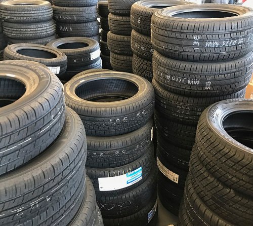 A large stack of black tires arranged in a storage area.