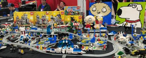 A colorful display of LEGO sets and figures, featuring a train track and characters from a popular animated show.
