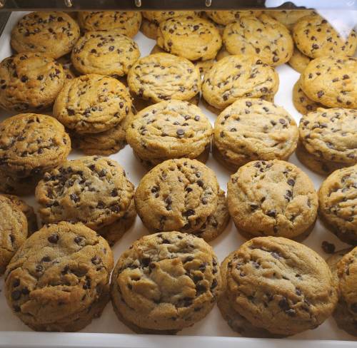 A tray filled with freshly baked chocolate chip cookies, golden brown and slightly chewy.
