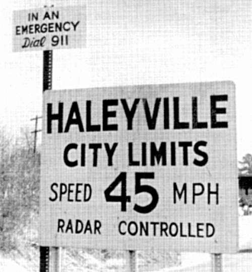 Sign indicating the city limits of Haleyville, with a speed limit of 45 MPH and a note to dial 911 in emergencies.