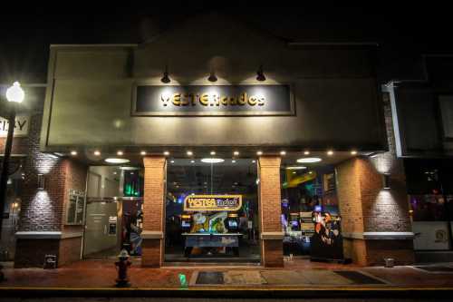 A brightly lit arcade entrance at night, featuring the name "METERgrades" and colorful game displays inside.