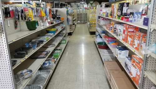 A store aisle filled with various kitchenware, including pots, pans, and baking supplies on both sides.