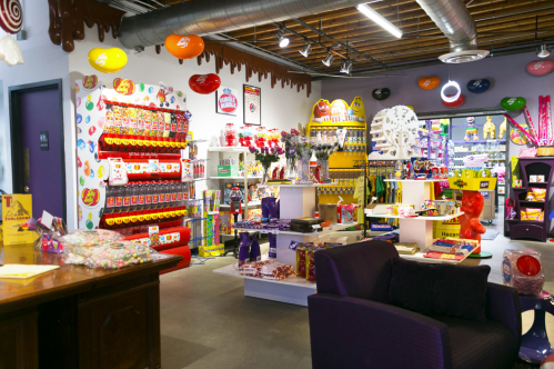 Colorful candy store interior filled with various sweets, jars, and decorations, creating a vibrant and inviting atmosphere.