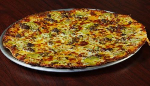 A large, round pizza topped with melted cheese, ground beef, and green toppings on a silver platter.