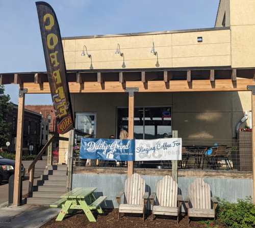 A coffee shop exterior with a banner celebrating 10 years, featuring outdoor seating and a colorful flag.