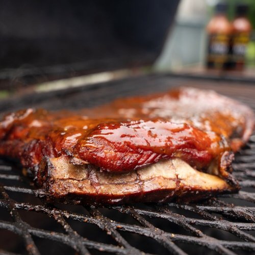 Close-up of a juicy, smoked brisket resting on a grill, showcasing a caramelized crust and tender meat.