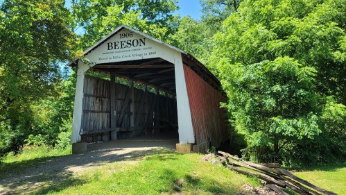 A historic covered bridge named Beeson, built in 1906, surrounded by lush greenery.