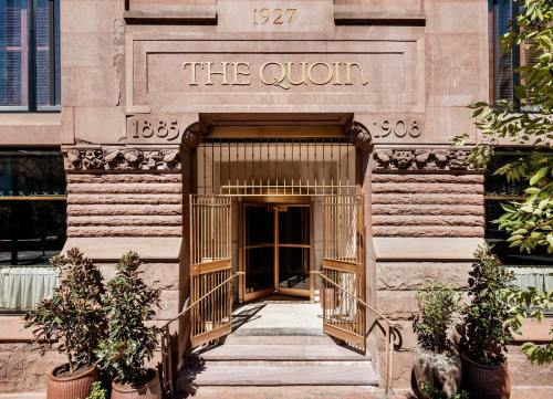 Entrance of The Quoin building, featuring ornate architecture and a decorative sign with the years 1885 and 1908.