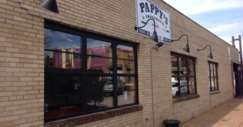 Exterior of Pappy's restaurant with large windows and a sign, featuring a brick facade and outdoor lighting.