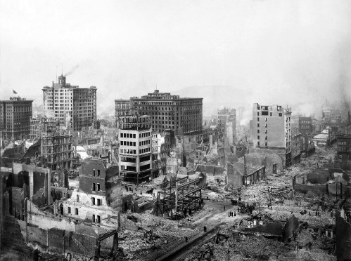 Aerial view of a devastated cityscape with destroyed buildings and rubble, depicting aftermath of a disaster.
