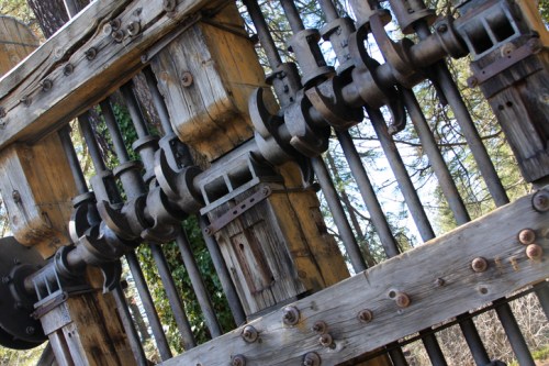 Close-up of a wooden structure with metal hooks and bars, showcasing intricate craftsmanship and design.