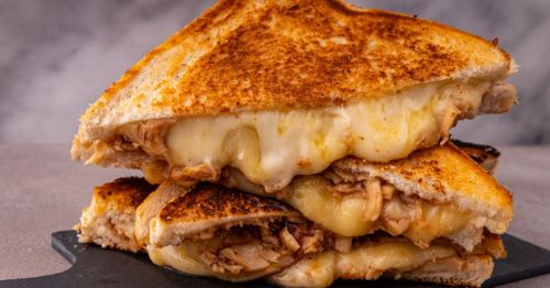 close up of loaded grilled cheese sandwich cut in half and stacked on top of one another