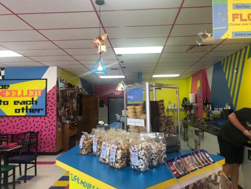 Colorful interior of a snack shop with a display of treats, a counter, and vibrant wall decorations.