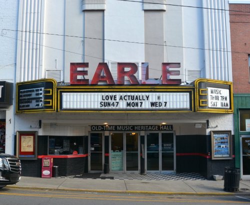 The Earle theater marquee displays "Love Actually" showtimes and music events, with a classic architectural style.