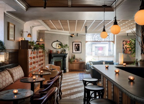 Cozy café interior with warm lighting, stylish seating, and a decorative fireplace, creating an inviting atmosphere.
