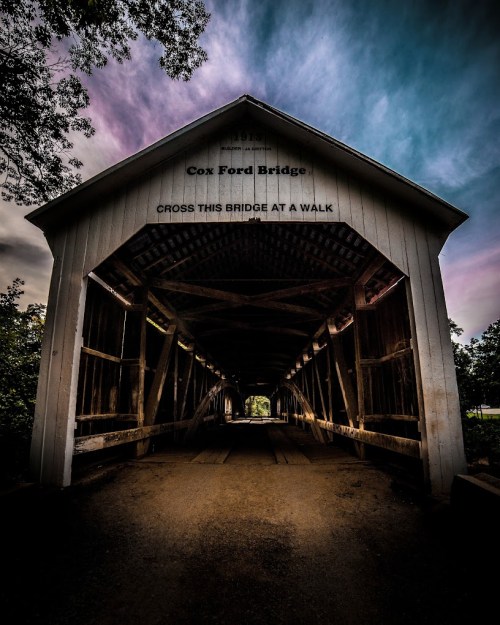 A view of Cox Ford Bridge, featuring a wooden structure and a dramatic sky above.