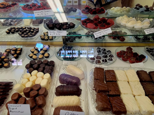 A display case filled with various chocolates and confections, including truffles, creams, and chocolate-covered treats.