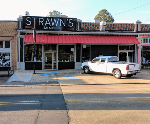 Exterior of Strawn's Eat Shop, featuring a red awning and a white pickup truck parked outside.
